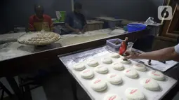 Pekerja menyelesaikan pembuatan kue bulan di Industri Rumahan Kue Bulan Putri Lauw, Pondok Sentul, Ciater, Tangerang Selatan, Selasa (10/11/2020). Pada masa pandemi sekarang, produksi kue tradisional khas Tionghoa tersebut menurun sesuai pesanan pembeli. (merdeka.com/Dwi Narwoko)