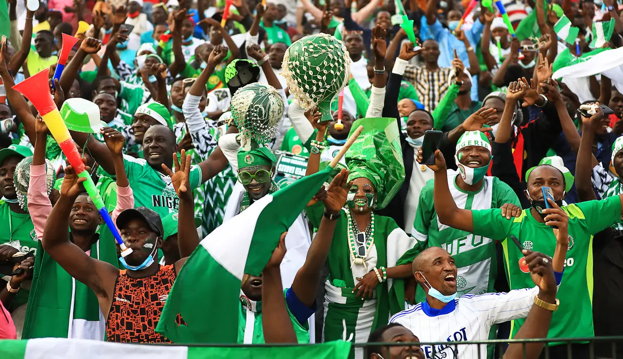 Pendukung Nigeria bersorak selama pertandingan Grup D Piala Afrika (CAN) 2021 antara Nigeria melawan Mesir di Stade Roumde Adjia di Garoua (12/1/2022). Nigeria menang tipis atas Mesir tipis 1-0 lewat gol Kelechi Iheanacho di menit ke-30. (AFP/Daniel Beloumou Olomo)