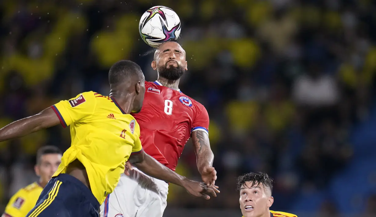 Gelandang Chile Arturo Vidal menyundul bola di bawah pengawasan gelandang Kolombia Matheus Uribe pada lanjutan Kualifikasi Piala Dunia 2022 zona Amerika Selatan di Estadio Metropolitano Roberto Meléndez, Jumat (10/9/2021). Dua gol Miguel Borja memastikan Kolombia menang 3-1.  (AP/Fernando Vergara)