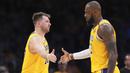 Pemain Los Angeles Lakers, Luka Doncic (kiri) bersalaman dengan LeBron James dalam laga lajutan NBA melawan Utah Jazz di Crypto.com Arena, Los Angeles, California pada Selasa (11/02/2025) WIB. (AP Photo/Mark J. Terrill)