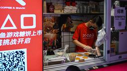 Seorang pria bekerja di toko kecil untuk dalgona, permen gula renyah yang ditampilkan dalam serial Netflix Squid Game, di Shanghai pada 12 Oktober 2021. Meski Netflix diblokir pemerintah China, tetapi serial Netflix Squid Game sukses meraih popularitas di Negeri Tirai Bambu itu. (Hector RETAMAL/AFP)