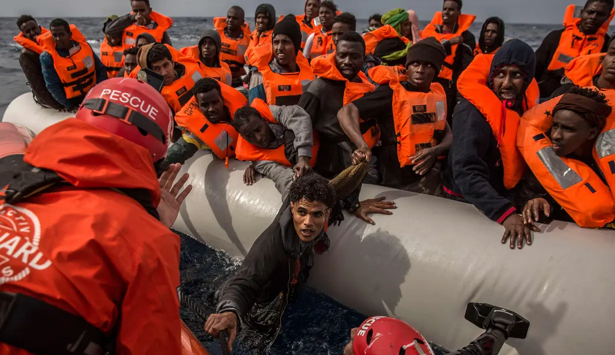 Petugas dari LSM Spanyol Proactiva Open Arms saat menyelamatkan pengungsi dan imigran setelah meninggalkan Libya yang mencoba mencapai tanah Eropa, 60 mil sebelah utara Al -Khum, Libya (18/2). (AP Photo/Olmo Calvo)