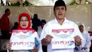 Calon Walikota Tangerang Selatan nomor urut 2 Arsid beserta istri menunjukan surat suara  di TPS 31 Kelurahan Pondok Benda, Tangsel, Rabu (9/12). Calon Walikota Tangerang Selatan ini merupakan pemilih perdana pada TPS tersebut. (Liputan6.com/Fery Pradolo)