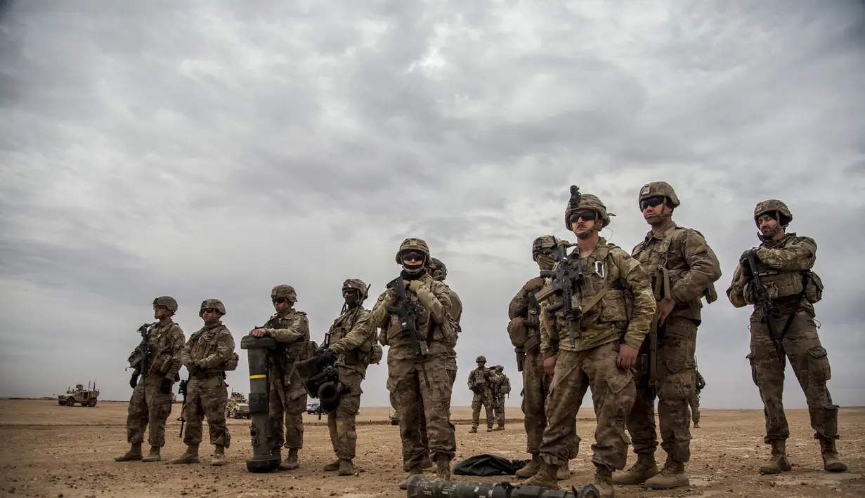Tentara Amerika berdiri selama latihan bersama dengan Pasukan Demokrat Suriah di pedesaan Deir Ezzor di timur laut Suriah (8/12/2021). Puluhan tentara Amerika dan Pasukan Demokrat Suriah berpartisipasi dalam latihan bersama satu hari.  (AP Photo/Baderkhan Ahmad)