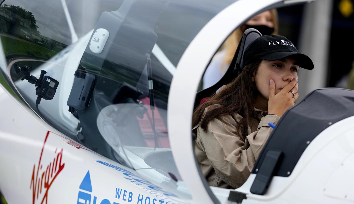 Remaja Belgia-Inggris Zara Rutherford duduk di kokpit pesawat Shark Ultralight-nya sebelum lepas landas di lapangan terbang Kortrijk-Wevelgem di Wevelgem, Belgia, Rabu (18/8/2021). Remaja Belgia-Inggris ini akan menjadi wanita termuda yang terbang solo keliling dunia. (AP Photo/Virginia Mayo)