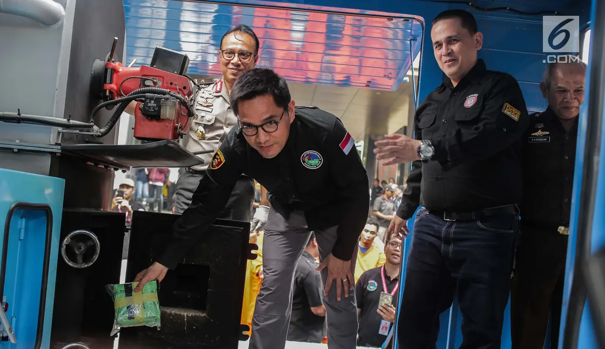 Wadir Tindak Pidana Narkoba Bareskrim Polri Kombes Krisno Siregar memasukkan narkoba ke dalam mesin insimilator saat pemusnahan barang bukti di Bareskrim Mabes Polri, Jakarta, Selasa (9/7/2019). Sebanyak 177,5 Kg sabu dan 30 ribu butir ekstasi dimusnahkan (Liputan6.com/Fazail Fanani)