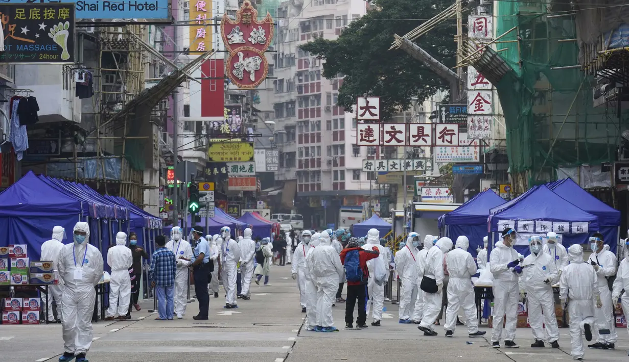 Penyelidik pemerintah yang mengenakan pakaian pelindung berkumpul di daerah Yau Ma Tei di Hong Kong, Sabtu (23/1/2021). Ribuan warga Hong Kong diperintahkan tetap tinggal di rumah setelah otoritas setempat memberlakukan penguncian ( lockdown ) untuk pertama kalinya sejak pandemi COVID-19 merebak. (A