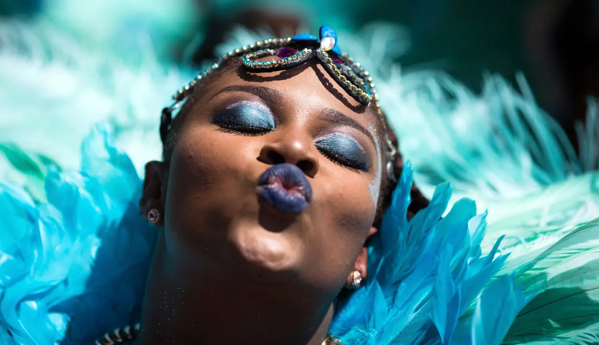 Seorang penari mengenakan kostum selama ambil bagian dalam Parade West Indian Day di Brooklyn borough, New York, Senin (4/9). Parade tersebut merupakan salah satu perayaan budaya Karibia terbesar di Amerika Serikat. (AP Photo/Kevin Hagen)
