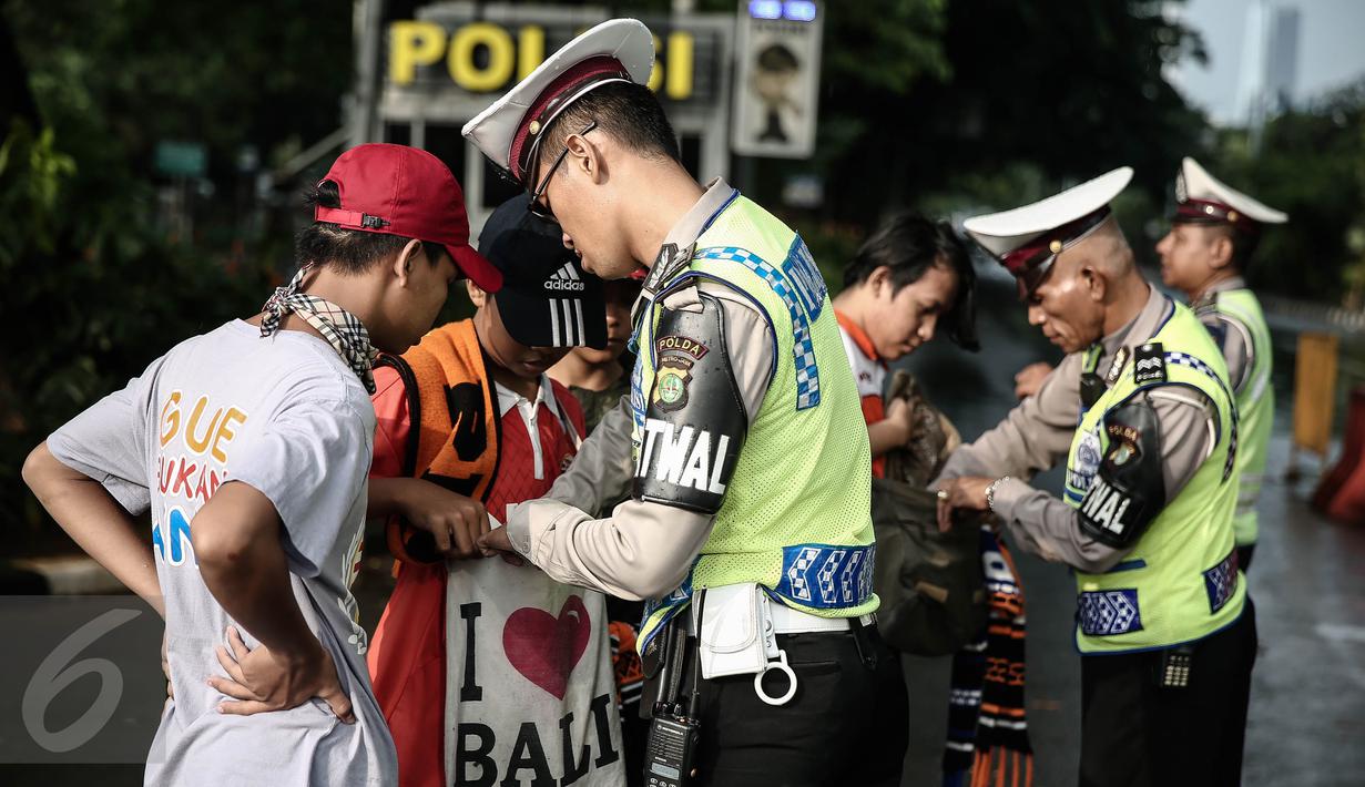 Petugas kepolisian merazia  suporter yang membawa barang berbahaya disekitar kawasan Gelora Bung Karno, Jakarta, Minggu (8/5/2016).Persija akan melawan Semen Padang pada lanjutan Torabika Soccer Championship 2016. (Liputan6.com/Faizal Fanani)