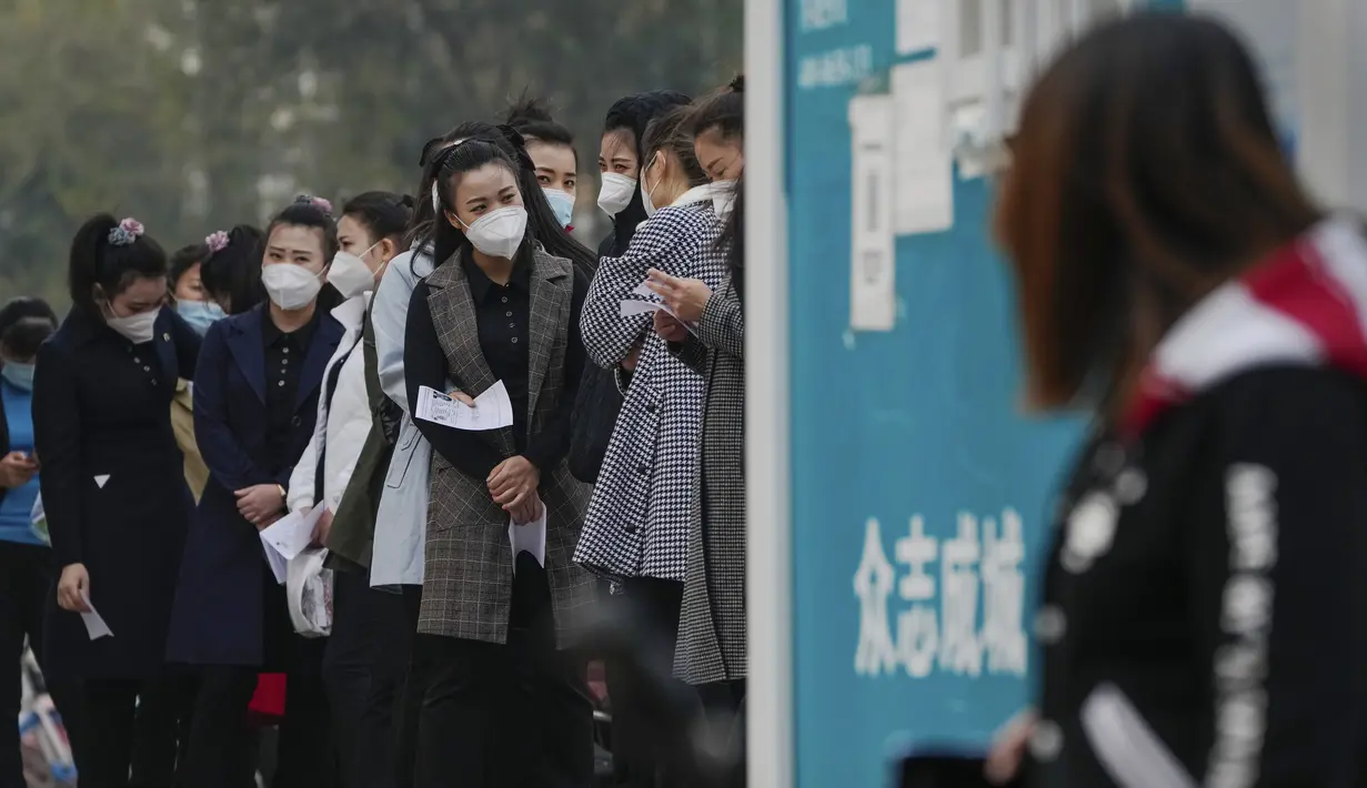 Wanita yang memakai masker wajah mengantre untuk mendapatkan tes usap tenggorokan COVID-19 rutin mereka di tempat pengujian virus corona di Beijing, Rabu (26/10/2022). Kota Shanghai di China mulai memberikan vaksin COVID-19 yang dapat dihirup pada hari Rabu di tempat yang tampaknya menjadi yang pertama di dunia. (AP/Andy Wong)