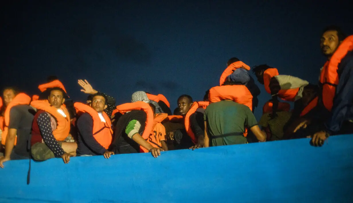 Imigran menunggu petolongan LSM Spanyol Open Arms di Laut Mediterania, Selasa (8/9/2020). Puluhan imigran termasuk wanita dan anak-anak asal Mesir, Maroko, Somalia, dan Sierra Leone menghabiskan lebih dari 20 jam saat melarikan diri dari Libya dengan kapal kayu. (AP Photo/Santi Palacios)