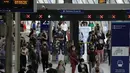Orang-orang memakai masker setelah turun dari kereta api pada jam sibuk pagi hari di stasiun Waterloo di London, Rabu (13/7/2021). Wali Kota Sadiq Khan menekankan transportasi publik di London akan terus memberlakukan kewajiban memakai masker setelah Senin (19/7) mendatang. (AP Photo/Matt Dunham)