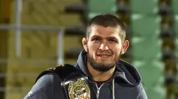 Juara kelas ringan UFC, Khabib Nurmagomedov membawa sabuk juaranya saat disambut oleh para penggemar setibanya di Makhachkala, Rusia, Senin (8/10). Nama Khabib menjadi terkenal setelah dirinya berhasil mengalahkan Conor McGregor. (AFP/Vasily MAXIMOV)