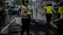 Polisi memadamkan aksi bakan ban yang dilakukan aktivis HMI di Jalan Cikini, Jakarta, Sabtu (8/10). Mereka menuntut Basuki Tjahaja Purnama (Ahok) mempertanggungjawabkan pernyataannya yang dinilai mencederai kitab suci Alquran. (Liputan6.com/Faizal Fanani)