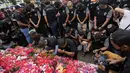 Pemain dan ofisial klub Arema FC berdoa dan menaburkan bunga untuk para korban kerusuhan Stadion Kanjuruhan Malang di Malang, Senin, 3 Oktober 2022. Tragedi Kanjuruhan itu pecah usai laga Arema FC menjamu Persebaya Surabaya yang berakhir dengan skor 2-3 untuk kemenangan tim tamu. (AP Photo/Achmad Ibrahim)