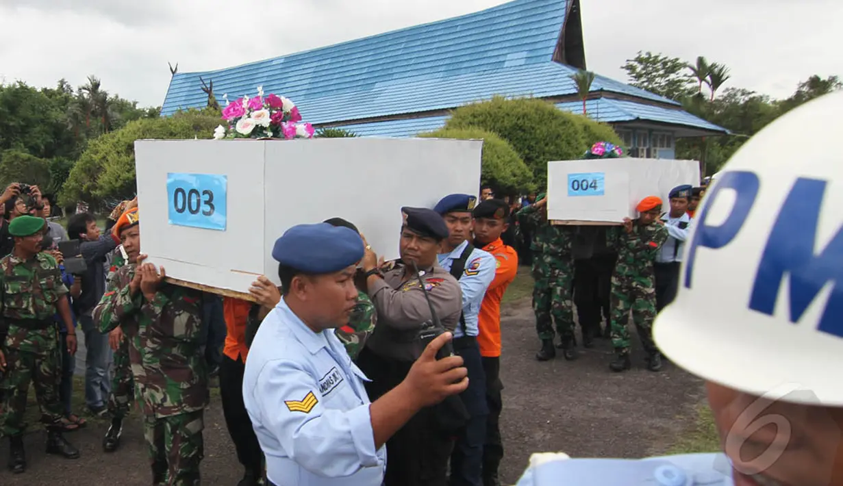 Puluhan prajurit mengangkat peti jenazah korban pesawat AirAsia QZ8501 yang di atasnya diberi karangan bunga di  Lanud Iskandar, Pangkalan Bun, Kalteng, Kamis (1/1/2015). (Liputan6.com/Herman Zakharia)