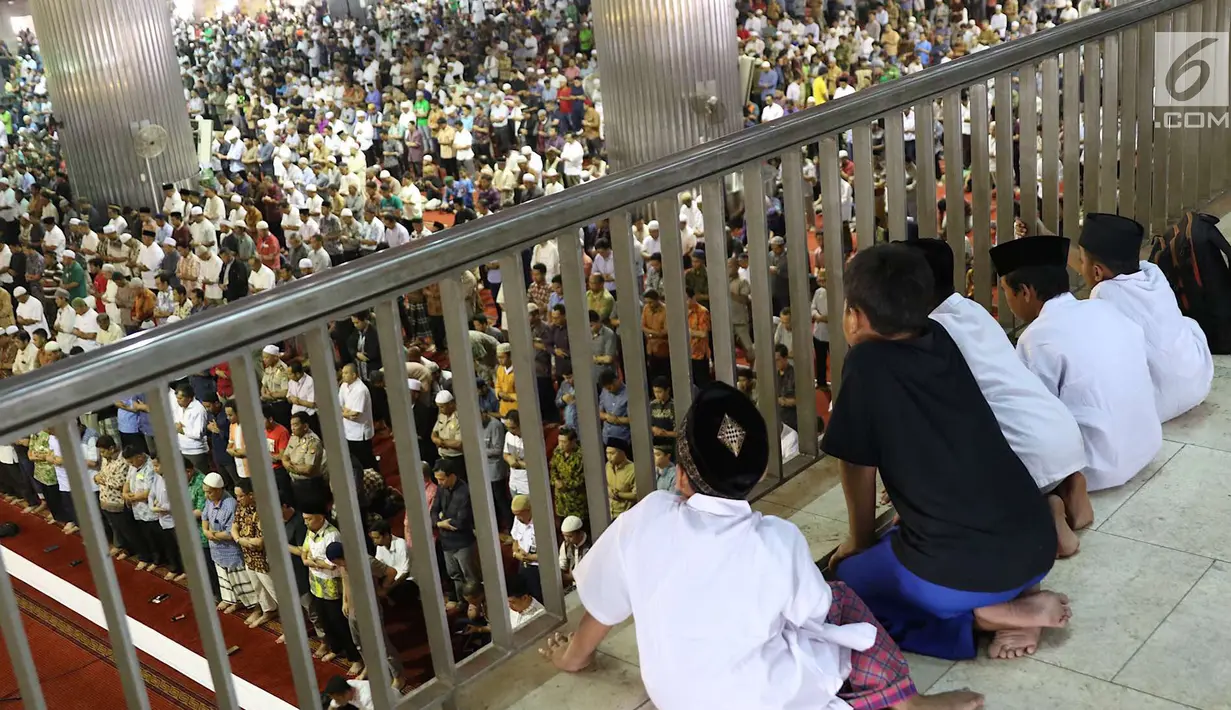 Sejumlah anak-anak mengamati umat muslim melaksanakan salat Jumat di Masjid Istiqlal, Jakarta, Jumat (18/5). Salat Jumat kali ini merupakan yang pertama di bulan Ramadan 1439 Hijriah. (Liputan6.com/Immanuel Antonius)
