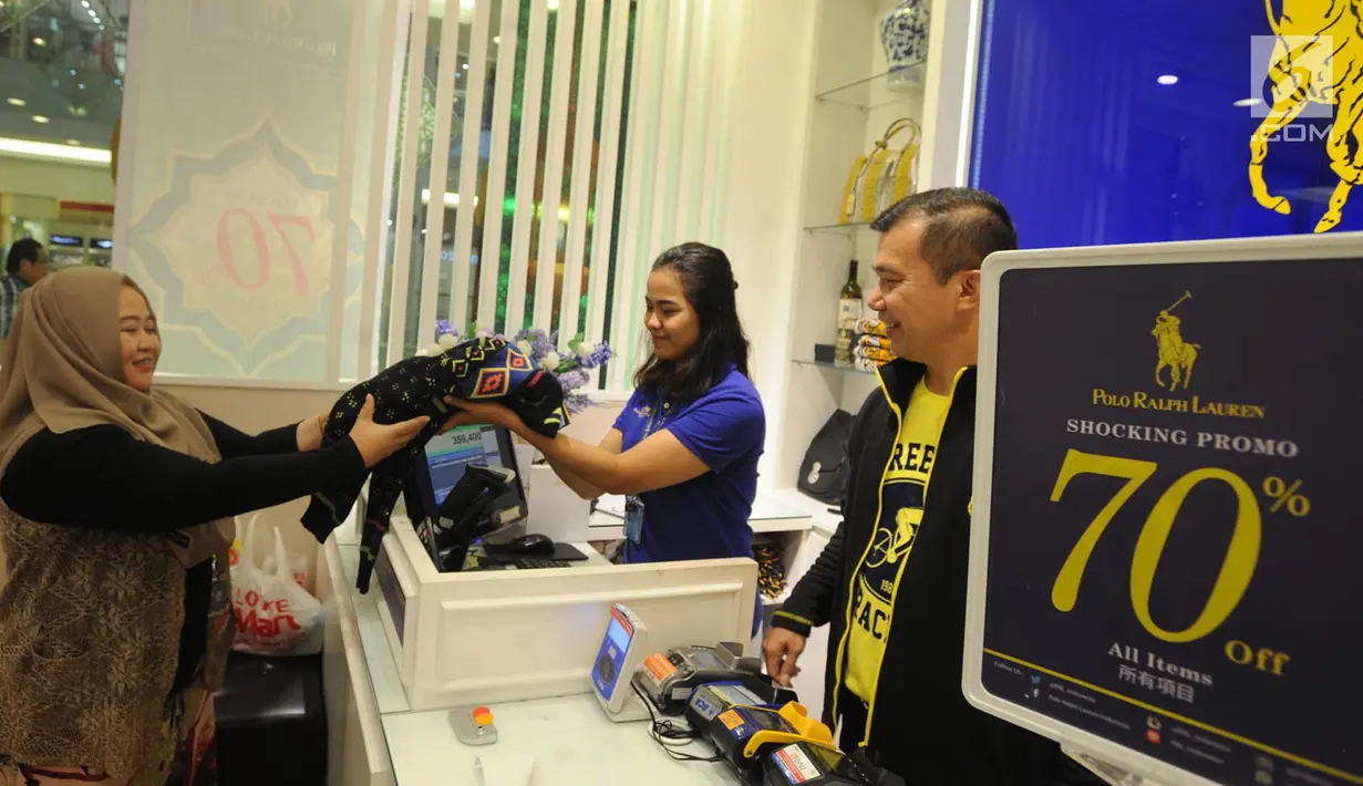Pengunjung membayar pakaian yang dibeli di Polo Ralph Lauren Indonesia di Gandaria City Mall, Jakarta (3/6). Dua pekan jelang Idul Fitri, sejumlah toko pakaian memberi diskon besar-besaran kepada pembeli. (Merdeka.com/Arie Basuki)