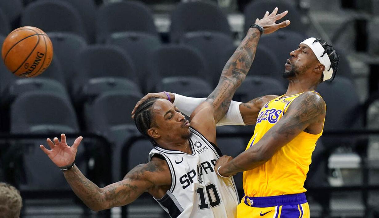 Pebasket Los Angeles Lakers, Kentavious Caldwell-Pope, berebut bola dengan pebasket San Antonio Spurs, DeMar DeRozan, pada laga NBA di AT&T Center, Kamis (31/12/2020). LA Lakers menang dengan skor 121-107. (AP/Eric Gay)