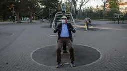 Seorang lansia berolahraga di sebuah taman di Beograd, Serbia (21/4/2020). Waktu tersebut bisa dimanfaatkan untuk berolahraga di taman atau jalan-jalan ringan dengan jarak maksimum 600 meter dari tempat tinggal. (AFP/Oliver Bunic)