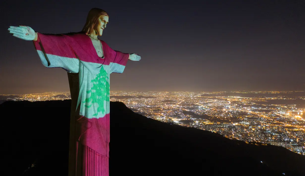 Patung Christ the Redeemer terlihat diterangi dengan bendera nasional Lebanon di Rio de Janeiro, Brasil, Kamis (6/8/2020). Tindakan tersebut sebagai bentuk solidaritas bagi para korban ledakan dahsyat yang mengguncang ibu kota Lebanon, Beirut pada Selasa (4/8) lalu. (AP Photo/Leo Correa)