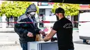 Staf perusahaan katering memberikan makanan gratis kepada pria di Berlin, Jerman (16/4/2020). Tingkat infeksi baru COVID-19 di Jerman terus berada di bawah masa puncak saat jumlah kasus terkonfirmasi bertambah 2.866 dalam satu hari menjadi 130.450. (Xinhua/Binh Truong)