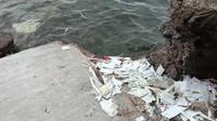 Sampah Bungkus Rapid Test Antigen  Berserakan di Pinggir Laut Selat Bali. (Hermawan Arifianto/Liputan6.com)