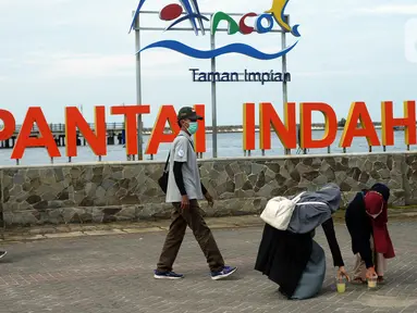 Petugas mengimbau pengunjung saat libur Tahun Baru di Pantai Ancol, Jakarta, Sabtu (1/1/2022). Memasuki libur akhir pekan awal Tahun Baru 2022, kawasan Taman Impian Jaya Ancol hanya buka dari jam 06.00-14.00 WIB, hal ini untuk mencegah penyebaran COVID-19 varian omicron. (merdeka.com/Imam Buhori)