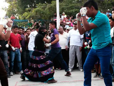 Sejumlah anak saling pukul saat mengikuti Tradisi Xochimilcas di Zitlala, Guerrero, Meksiko (18/2). Tradisi ini berasal dari warga pribumi atau keturunan dari Suku Aztec. (AFP PHOTO/Pedro Pardo)