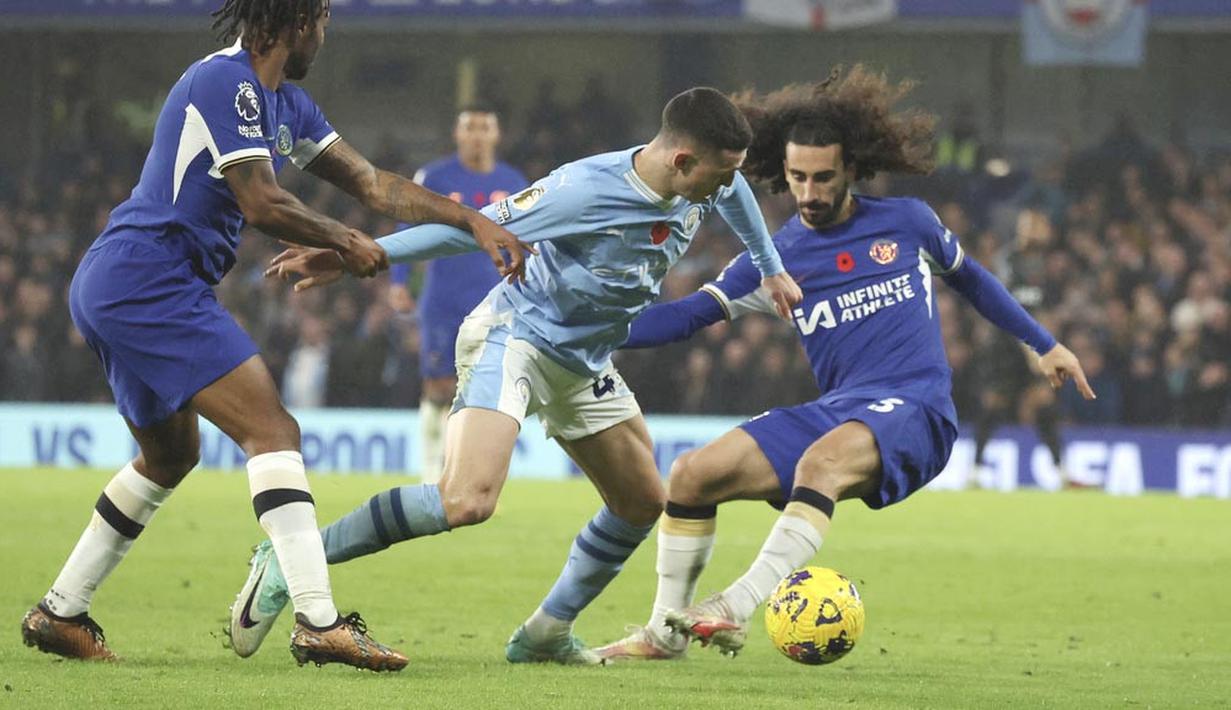 Pemain Manchester City, Phil Foden, berusaha melewati pemain Chelsea, Marc Cucurella, pada laga pekan ke-12 Premier League 2023/2024 di Stadion Stamford Bridge, Minggu (12/11/2023). Pertandingan ini amat sangat seru. Chelsea dan City saling adu serangan dan saling balas mencetak gol. (AP Photo/Ian Walton)