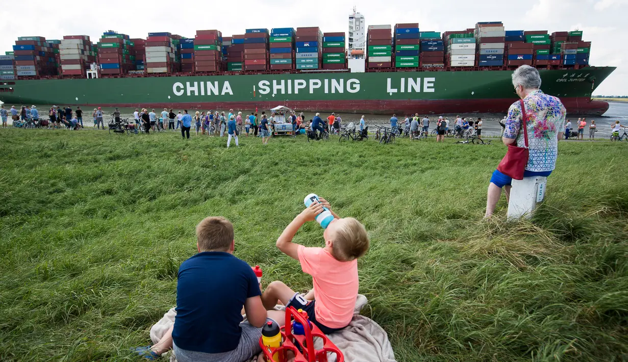 Sejumlah warga berkumpul di lokasi dimana kapal kontainer CSCL Jupiter Hong Kong terdampar di muara Westerschelde di dekat kota Bath di Belanda setelah insiden grounding (14/8).  (AFP PHOTO/Belga/Kristof Van Accom/Belgium Out)