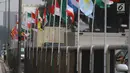 Deretan bendera negara-negara peserta Asian Games 2018 yang diikat di tiang bambu di pagar pembatas Jalan Pluit Selatan Raya, Jakarta, Kamis (19/7). Pemasangan bendera itu sempat menuai kritikan warganet di media sosial. (Liputan6.com/Arya Manggala)