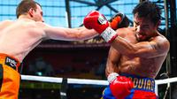 Petinju Filipina, Manny Pacquiao, menangkis pukulan dari Jeff Horn (Australia) pada perebutan sabuk juara kelas welter versi WBO di Stadion Suncorp, Brisbane, Minggu (2/7). Horn yang tak diunggulkan justru mampu mengalahkan Pacquiao (PATRICK HAMILTON/AFP)