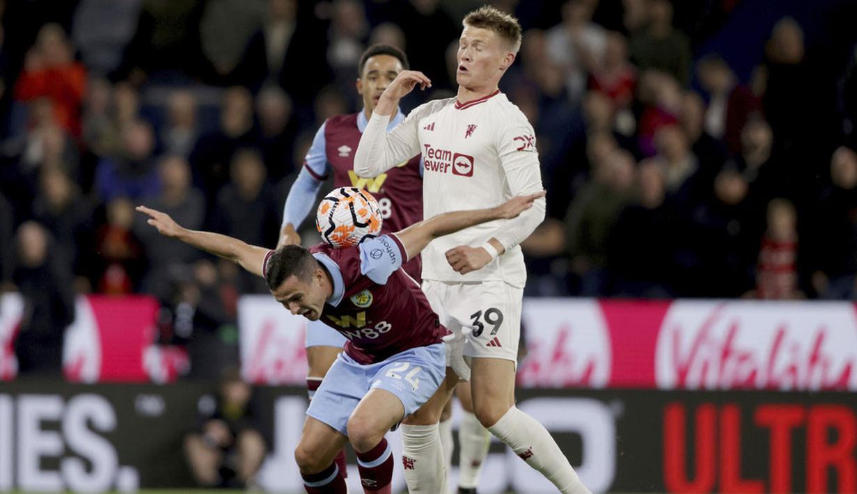 Pemain Manchester United, Scott McTominay, berebut bola dengan pemain Burnley, Zeki Amdouni, pada laga Liga Inggris di Stadion Turf Moor, Minggu (24/9/2023). (Ian Hodgson/PA via AP)
