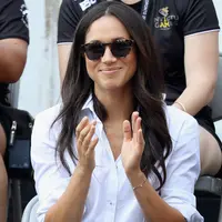 Kekasih Pangeran Harry yang juga aktris, Meghan Markle menonton pertandingan tenis kursi roda selama Invictus Games 2017 di Toronto, Kanada, Senin (25/9). Meghan tampil lebih kasual dengan kemeja putih dan jeans skinny. (Chris Jackson/GETTY IMAGES/AFP)