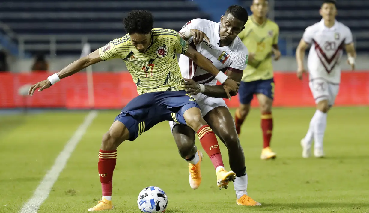 Bek Kolombia, Johan Mojica, berebut bola dengan penyerang Venezuela, Sergio Cordova, pada laga kualifikasi Piala Dunia 2022 zona Amerika Selatan di Estadio Metropolitano, Sabtu (10/10/2020) pagi WIB. Kolombia menang 3-0 atas Venezuela. (AFP/Mauricio Duenas/pool)