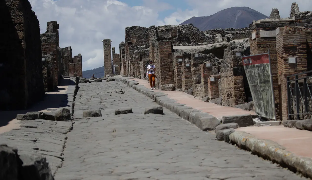 Seorang perempuan mengunjungi situs arkeologi Pompeii seusai kebijakan lockdown selama dua bulan untuk mengendalikan penyebaran Covid-19 di Italia, Selasa (26/5/2020). Salah satu situs arkeologi paling terkenal di dunia ini dibuka kembali untuk umum pada 26 Mei. (AP Photo/Alessandra Tarantino)