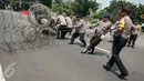 Polisi memasang kawat berduri pada peringatan May Day di depan Istana Negara, Jakarta, Senin (1/5). Istana Negara menjadi titik konsentrasi puluhan ribu buruh yang memperingati Hari Buruh Internasional. (Liputan6.com/Gempur M Surya)