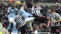 Pemain Newcastle United, Jamaal Lascelles, duel udara dengan bek Manchester City, John Stones, pada laga Premier League di Stadion James Park, Selasa (29/1). Newcastle United menang 2-1 atas Manchester City. (AP/Richard Sellers)