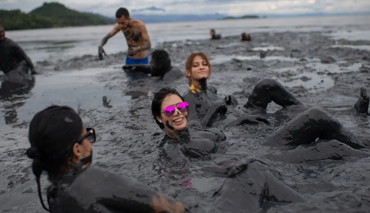 Sejumlah wanita berendam saat mengikuti Bloco da Lama", pesta mandi lumpur di Paraty, negara bagian Rio de Janeiro, Brasil (2/3). Bloco da Lama" diketahui sudah ada sejak 1986 lalu. (AFP Photo/Mauro Pimentel)