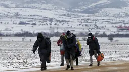 Sejumlah imigran berjalan melewati hamparan salju setelah menyeberang dari perbatasan Macedonia di dekat desa Miratovac, Serbia, (18/1/2016). (REUTERS/Marko Djurica)