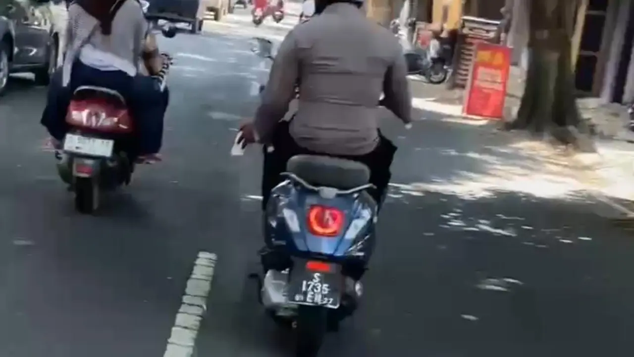 Polisi naik motor sambil merokok