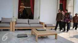 Presiden Joko Widodo (kiri) ditemani para pengurus untuk memulai proses pencetakan kaki dan tangannya di Istana Merdeka, Jakarta, Selasa (13/10/2015). Cetakan tersebut akan diletakkan di Taman Pintar Yogyakarta. (Liputan6.com/Faizal Fanani)   