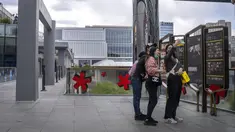 Orang-orang berfoto selfie di sebuah concourse kosong di pusat perbelanjaan yang biasanya ramai di akhir pekan, setelah banyak bisnis diperintahkan untuk tutup sebagai bagian dari pembatasan COVID-19 di distrik Chaoyang di Beijing, Sabtu, 14 Mei 2022. China dengan tegas menolak kritik terhadap kebijakan "nol-COVID" tanpa kompromi. (AP Photo/Mark Schiefelbein)