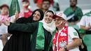 Dua fans wanita Arab Saudi berpose dengan pendukung Polandia sebelum pertandingan grup C Piala Dunia antara Polandia dan Arab Saudi, di Education City Stadium di Al Rayyan, Qatar, Sabtu, 26 November 2022. (AP Photo/Aijaz Rahi)