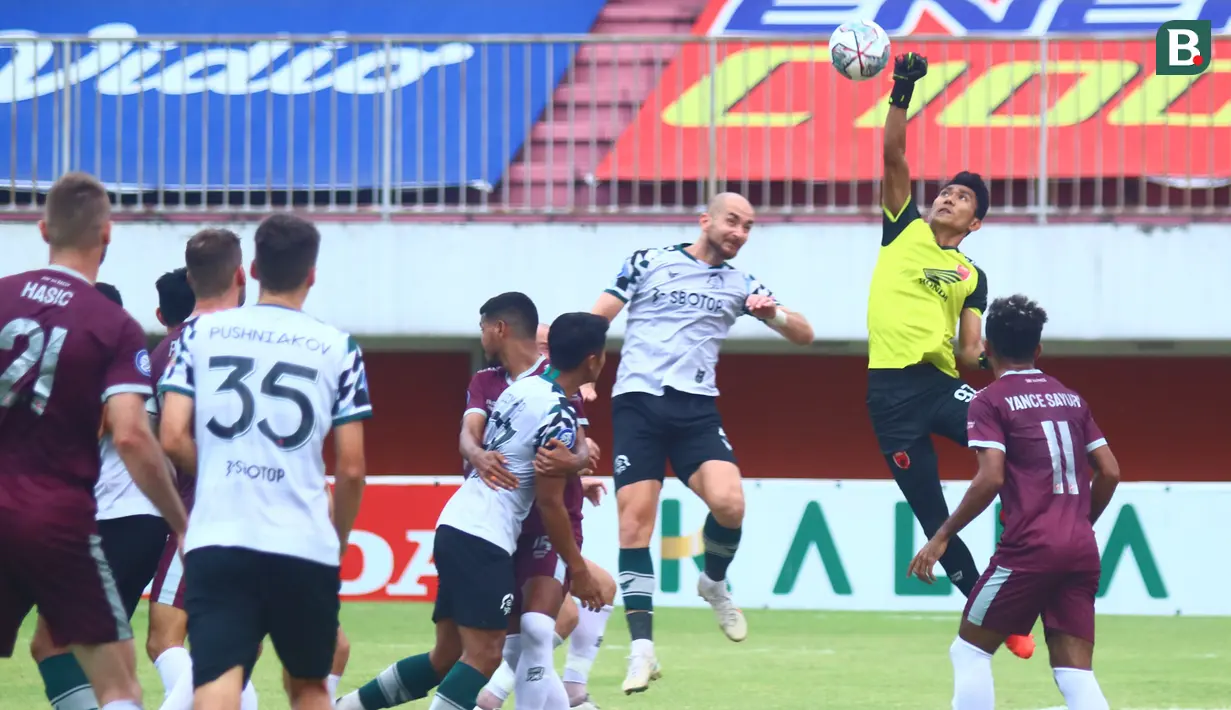 Kiper PSM Makassar, Hilman Syah (kanan) mencoba menghalau bola dari ancaman pemain Persikabo 1973, Veniamin Shumeyko dalam laga pekan ke-9 BRI Liga 1 2021/2022 di Stadion Maguwoharjo, Sleman, Selasa (26/10/2021). (Bola.com/Nandang Permana)