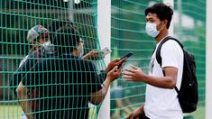 Kiper Timnas Indonesia, Muhammad Riyandi, melakukan wawancara dari balik jaring usai latihan di Lapangan D, Senayan, Jakarta. (Bola.com/ M Iqbal Ichsan)