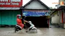 Hujan yang turun pada Minggu siang 16 Februari 2014 di sekitar Kota Kediri membuat sejumlah jalan tergenang seperti yang tampak di wilayah Karang Dinoyo (Liputan6.com/Helmi Fithriansyah).