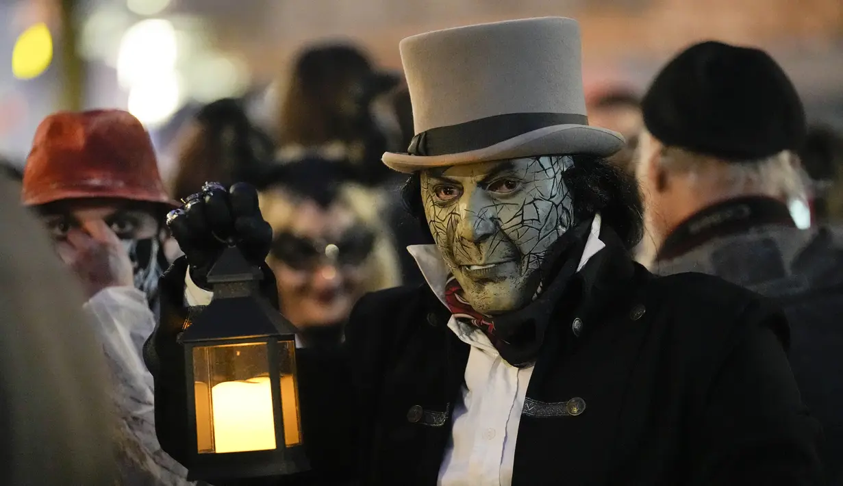 Orang-orang yang mengenakan kostum menakutkan berpartisipasi dalam Zombie Walk dan Parade Halloween tahunan di Essen, Jerman, Minggu (31/10/2021). Setiap 31 Oktober sebagian masyarakat dunia ikut memeriahkan perayaan Halloween. (AP Photo/Martin Meissner)