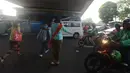 Polwan Polres Jakarta Timur mengenakan kebaya ketika membantu pejalan kaki menyeberang lintas di Jalan Otista Raya, Jatinegara, Jumat (20/4). Para polwan itu berkebaya dalam mengatur lalu lintas untuk memperingati Hari Kartini. (Merdeka.com/Imam Buhori)